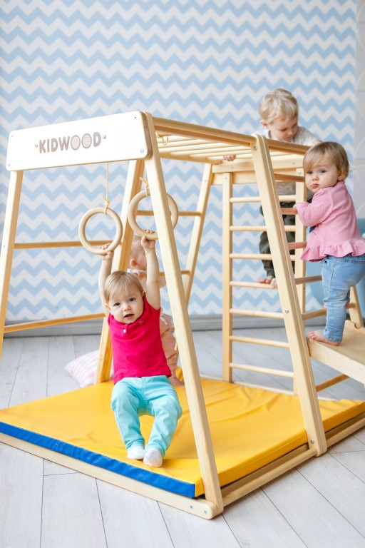 KIDWOOD rakéta fa mászóváz. Maximális megelégedettség azok számára, akik a legmagasabb magasságok elérésének vágyát akarják meghonosítani a gyermekben. Az oldalra fordított oldal megváltoztatása új lehetőségeket nyit meg. A létra felfelé vezet, közvetlenül a mászókeret tetejére. A majomlétra fejleszti a gyermekek koordinációját, és erősíti a karok és a hát különböző izomcsoportjait. Az oldalsó létra érdekes kiegészítője a játékkészletnek. Gyermeke bármely oldalról feljuthat a majomoszlopokra. Méretek: alap 113 * 115 cm, magasság 110 cm. Az alapkészlet alkatrészei: függőleges létrával és nagy ablakkal ellátott oldal, majomlábak,  oldalra szerelt létra trapéz alakú oldal, oldalra szerelhető létrával ellátott oldal, nyitott oldal alakú trapéz, mat. Kiváló minőségű kivitel, biztonságos és ökológiai anyagok - tömör fa és rétegelt lemez orosz nyírból + vízbázisú lakk. Biztonsági és kémiai vizsgálatok az EN71, TUV Rheinland tanúsítványok szerint.
Fa játszótér
Matrac
Fa csúszda kettős felülettel
Torna gyűrűk 
Eg - 2